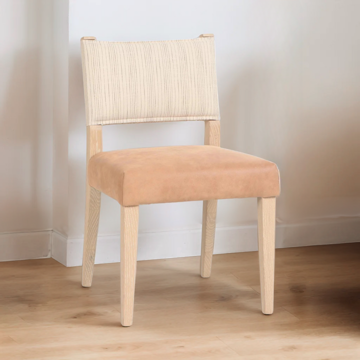Chair with beige cushioned seat and woven backrest against a plain wall.