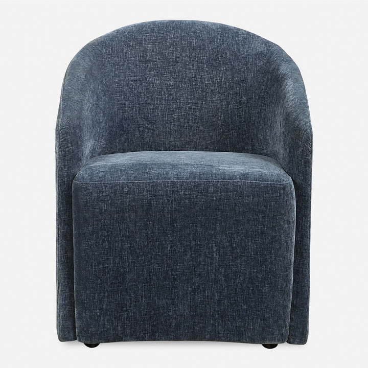 A blue upholstered dining chair with a unique barrel back design and rolling casters.