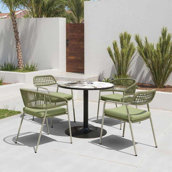 Outdoor patio set with four green chairs and a round table on a concrete patio.