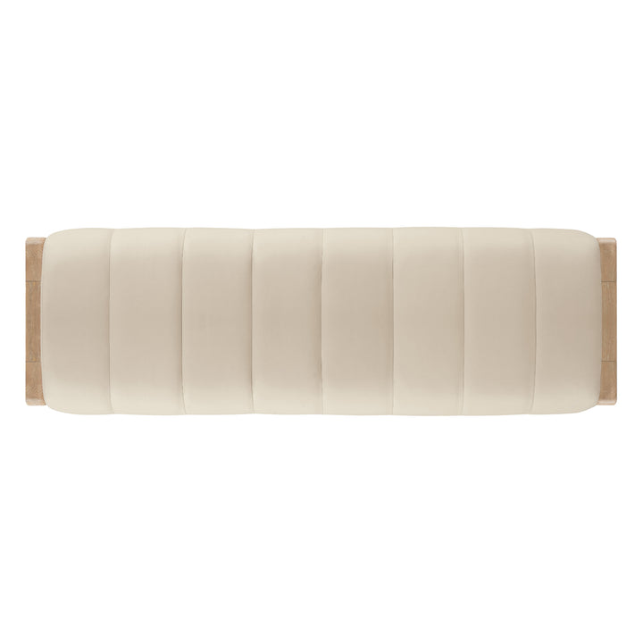 A minimalist, cream-colored upholstered bench with vertical tufting and light wood accents, viewed from above.