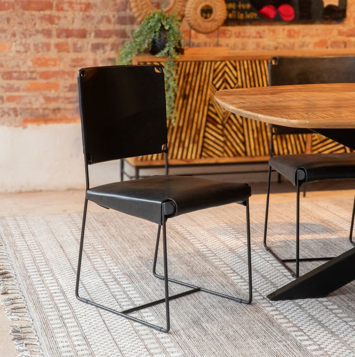 Modern black chair with metal legs in a casual dining setting.