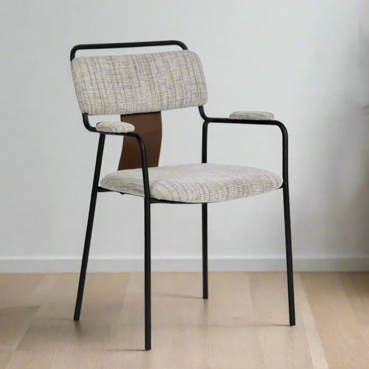 Chair with patterned backrest and seat on a wooden floor against a light-colored wall