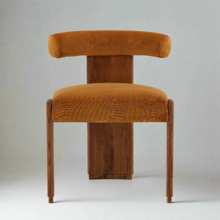 Orange velvet chair with wooden legs on a white background