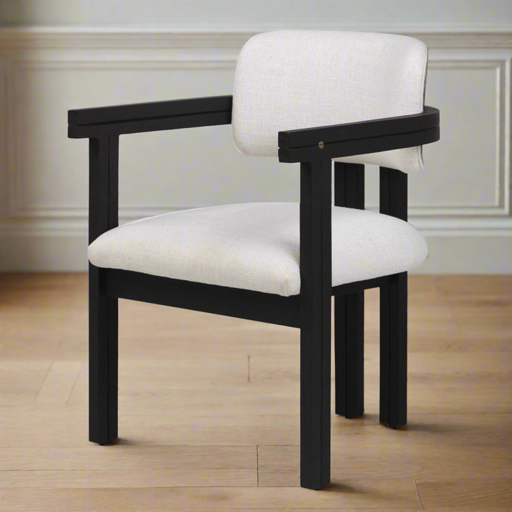 Chair with black frame and white cushion on a wooden floor.