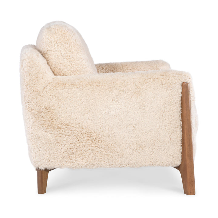 Side view of a cream-colored faux-shearling accent chair with mid-century modern wooden legs.