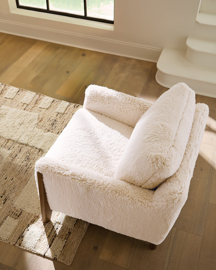 Top view of a cream-colored faux-shearling accent chair with mid-century modern wooden legs.