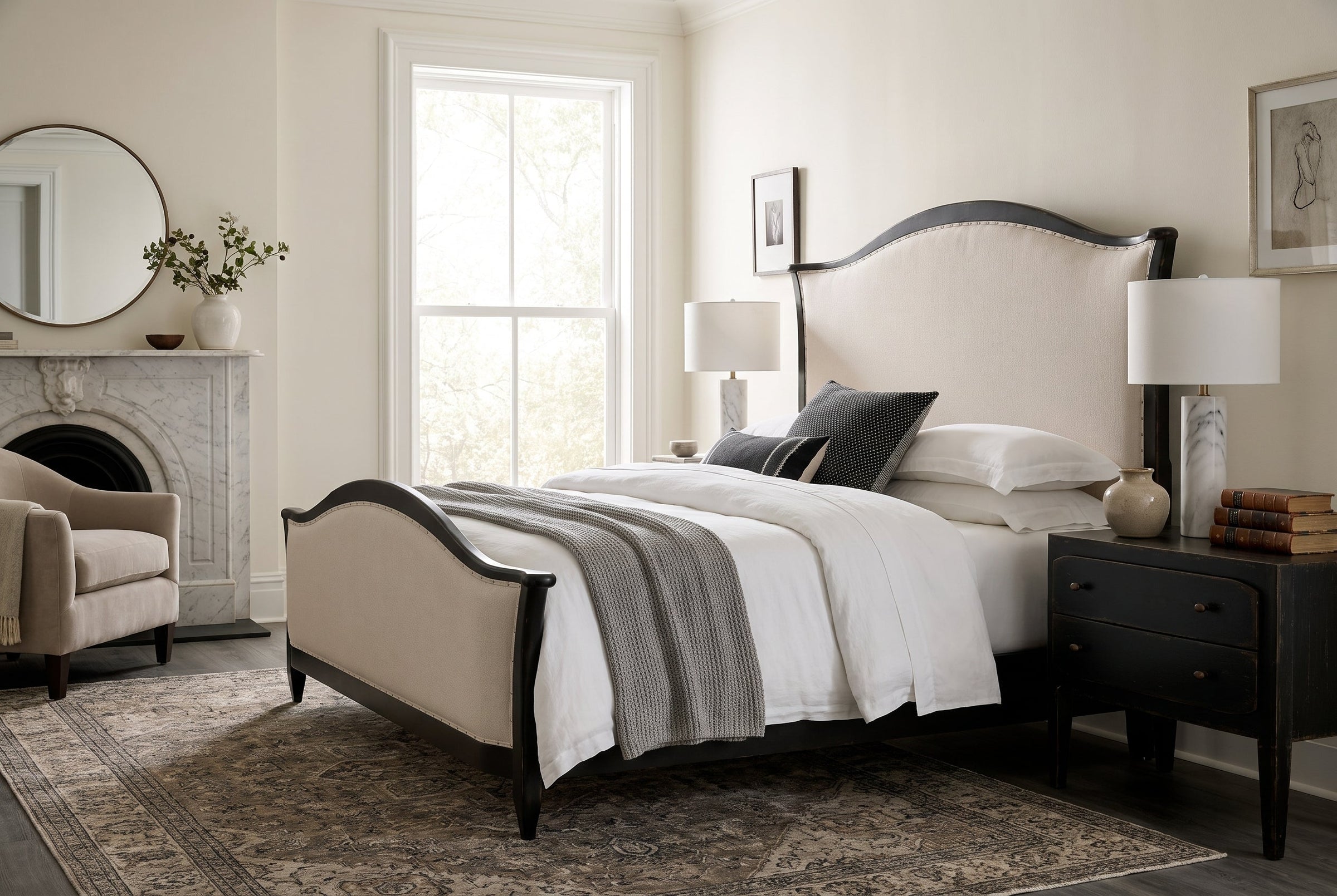 Elegant bedroom featuring a neutral upholstered bed, dark wood frame, marble fireplace, and sophisticated decor.