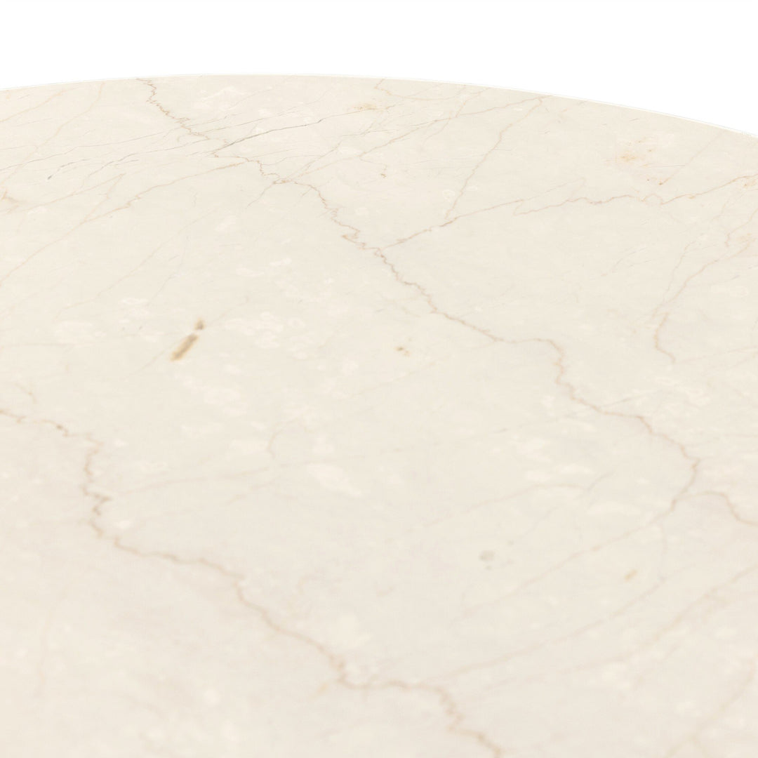 Close-up of a smooth, light-colored marble table surface, showcasing delicate veins and subtle texture.