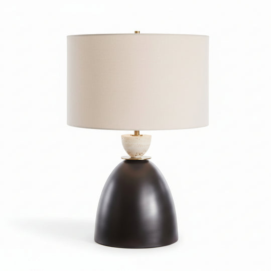 Table lamp with a black base and beige shade on a white background