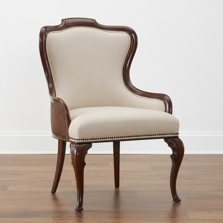 A classic wingback armchair with a dark brown carved wood frame, beige textured fabric upholstery, and decorative nailhead trim