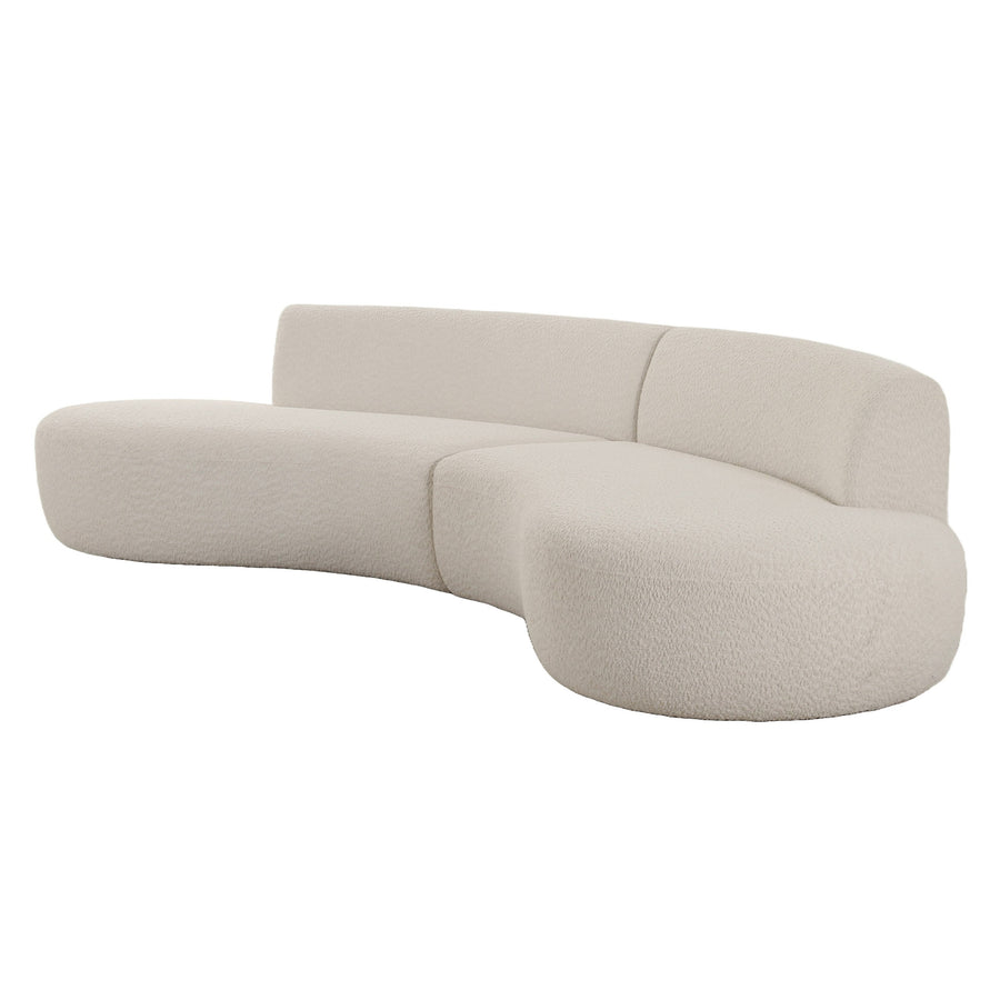 Curved, modern sofa upholstered in soft, cream fabric, featuring a minimalist design.