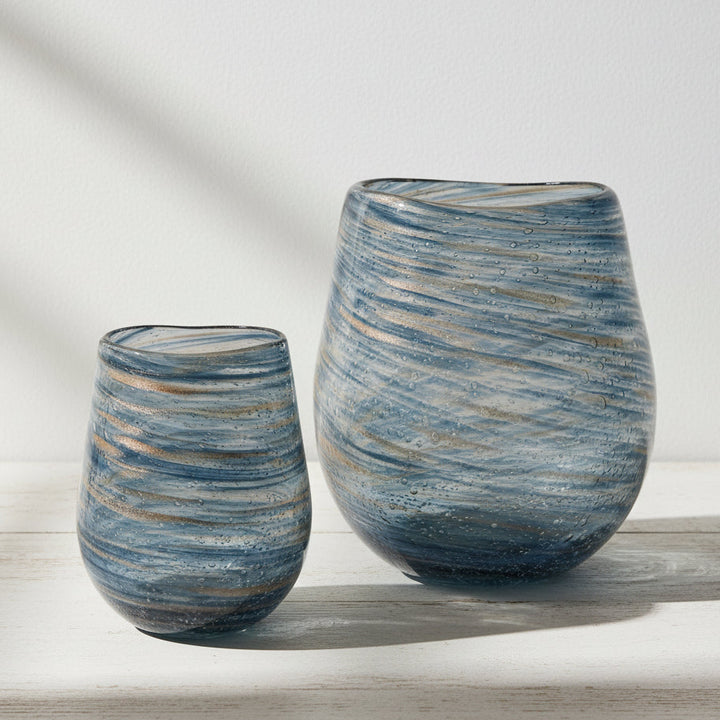 Two glass vases with a swirled blue and gold geometric pattern, one larger than the other.