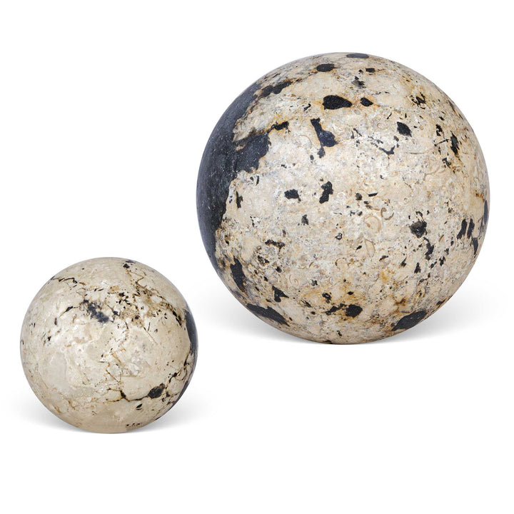 Two marble-like spherical objects on a wooden surface