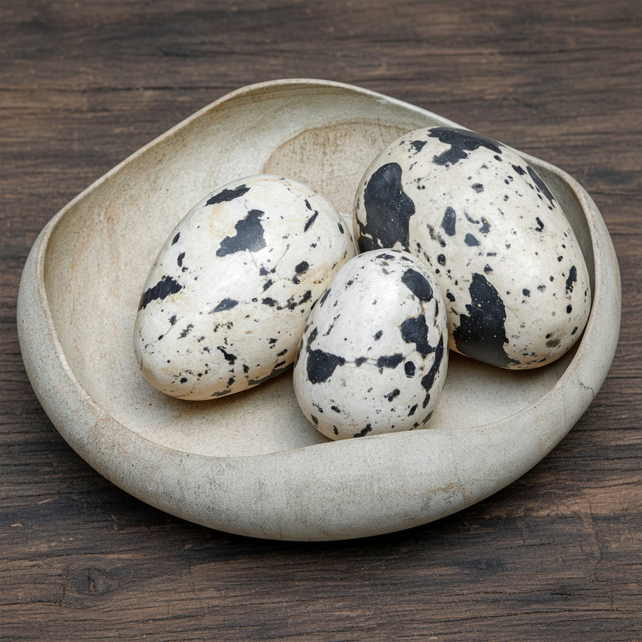 Three speckled eggs in a ceramic dish
