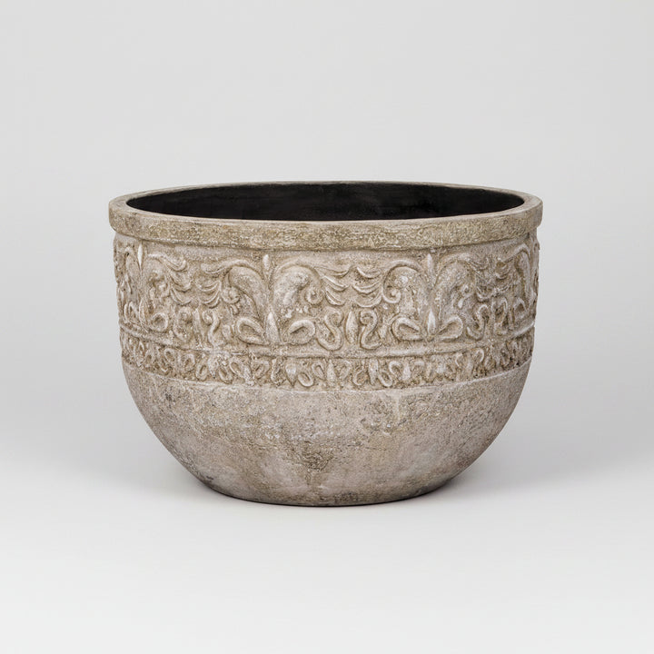 Decorative stone planter with intricate patterns on a white background