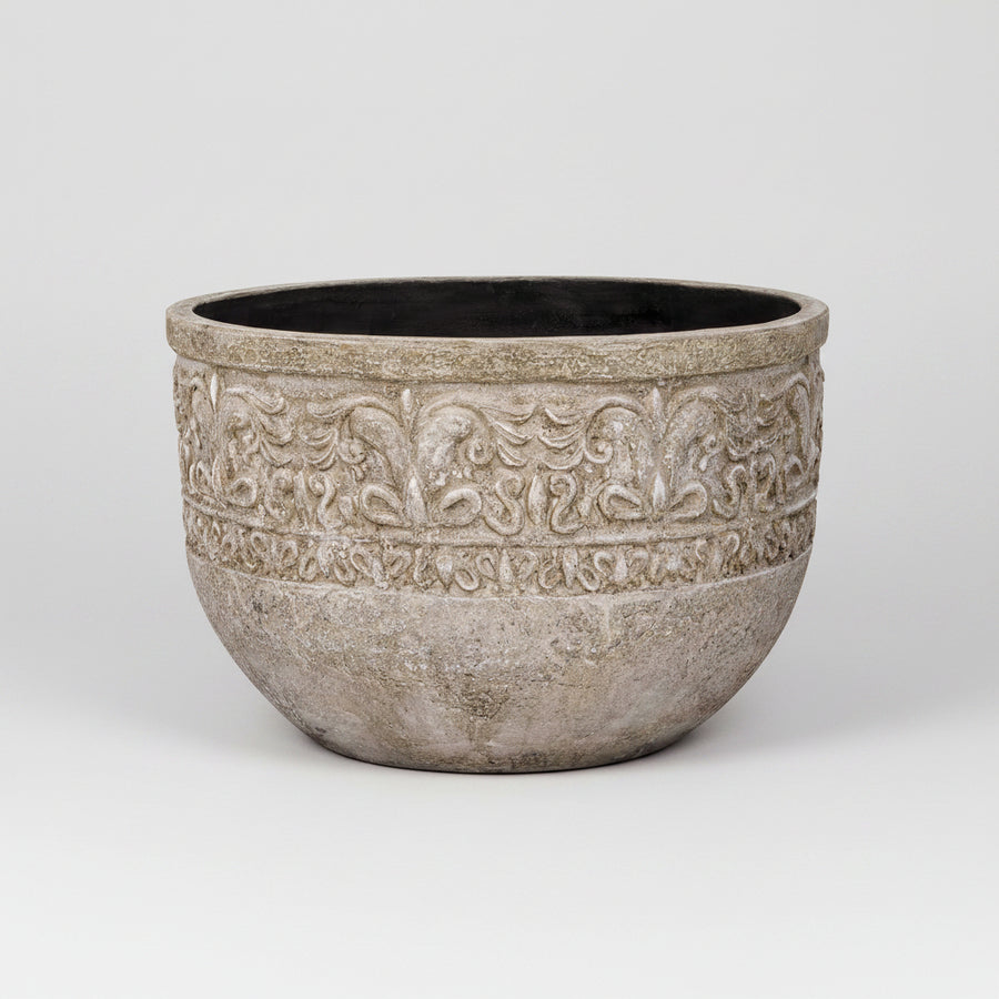Decorative stone planter with intricate patterns on a white background