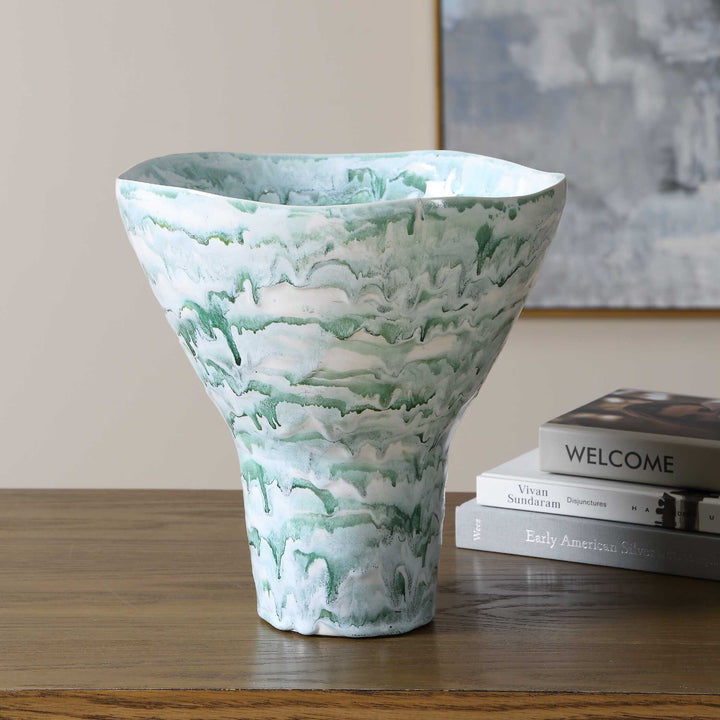 A tall, flared ceramic vase with a white and mint green marbled pattern