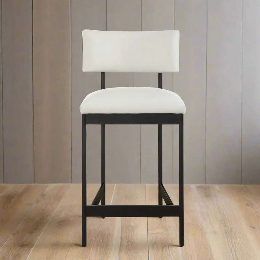 White bar stool with black legs on a wooden floor and gray paneled wall background