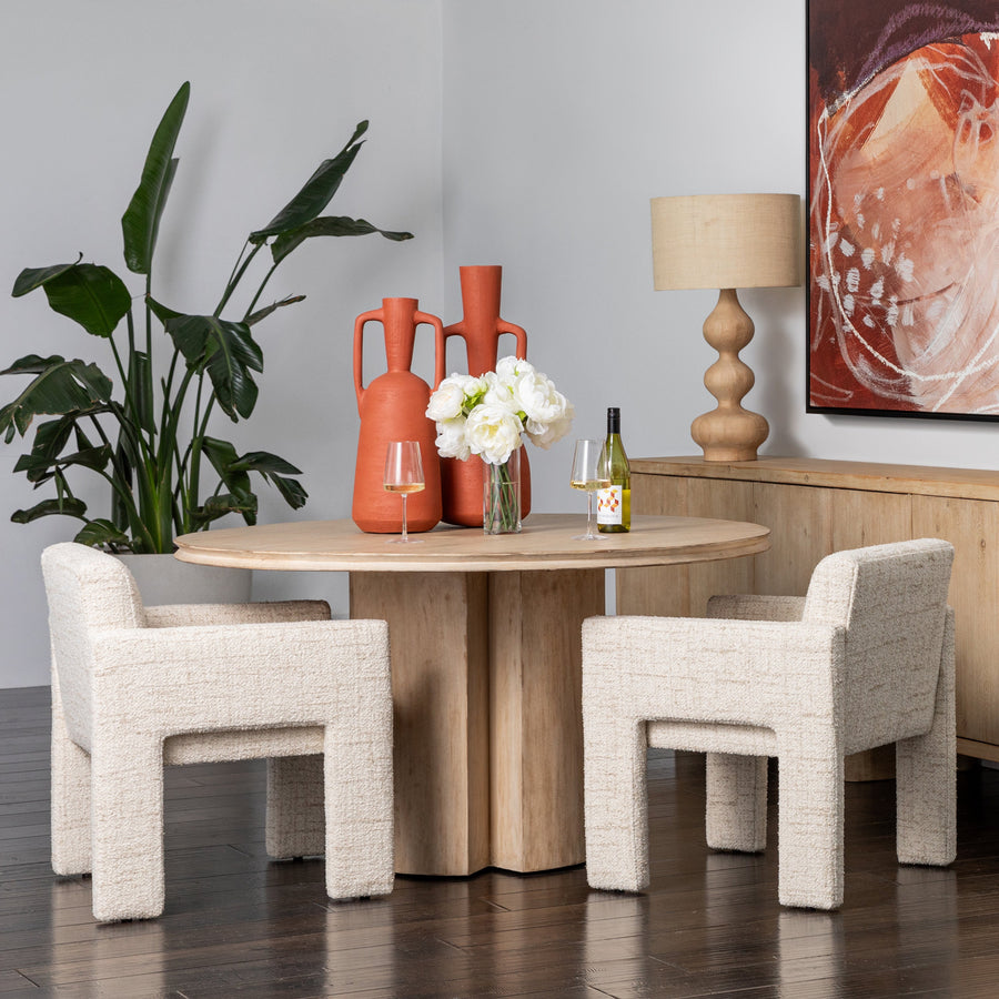 Dining room with wooden table, chairs, and decorative items.