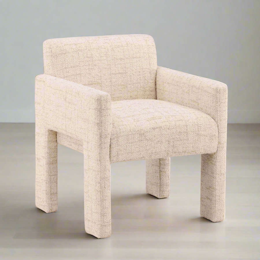 cream armchair on a wooden floor with a beige wall background