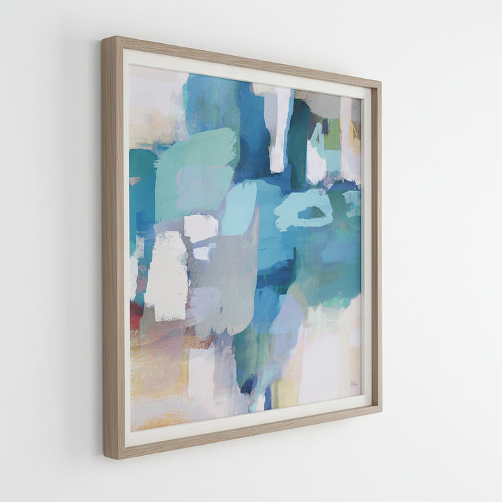 A framed abstract print featuring shades of azure and cyan with pops of white and yellow, bordered by a white linen liner and a pine wood frame in light gray stain with white wash accents
