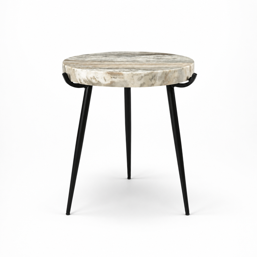 A round side table with a natural bone or agate top featuring beige and gray marbling, supported by three black metal legs with decorative loop details.