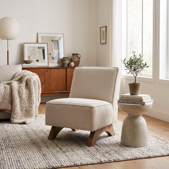 Modern living room featuring a textured beige accent chair, concrete side table, and minimalist decor in a neutral palette.