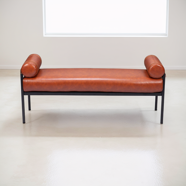 Brown leather bench with black metal frame on a white floor and wall