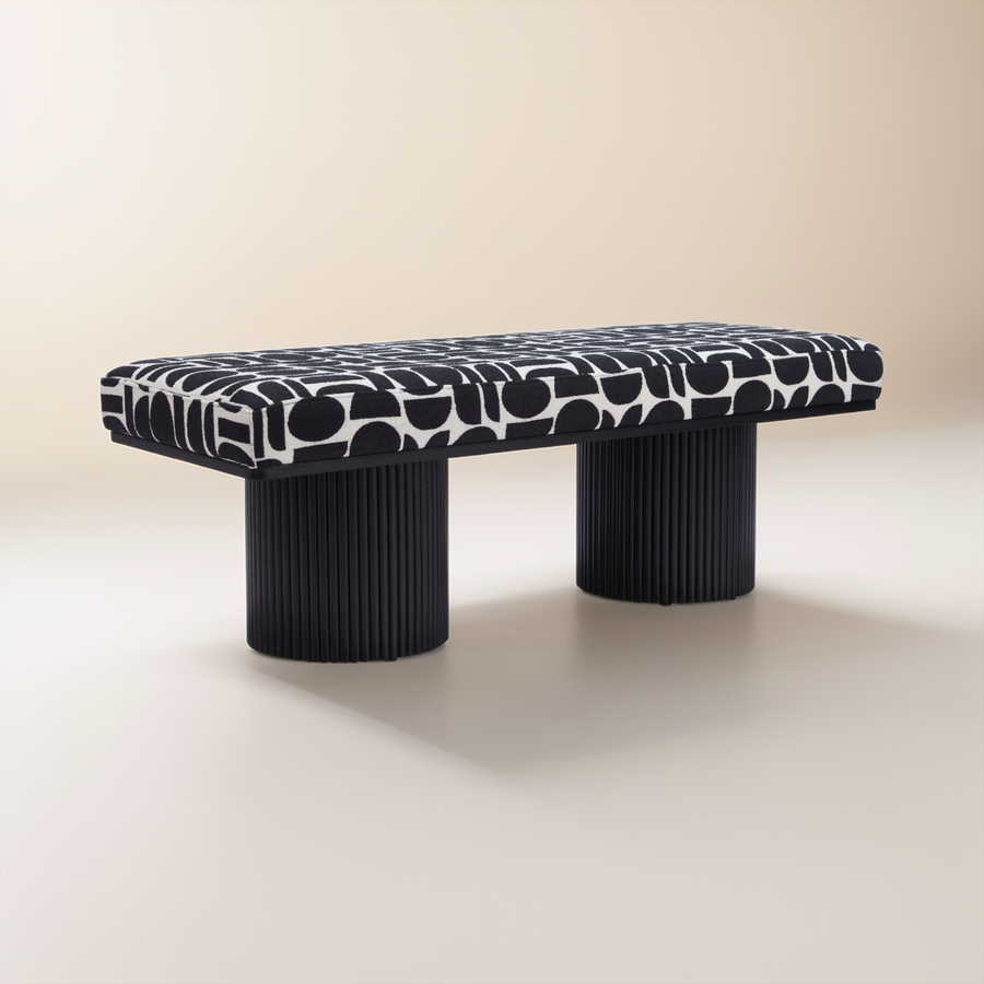 Modern bench with patterned top and black cylindrical legs on a beige background