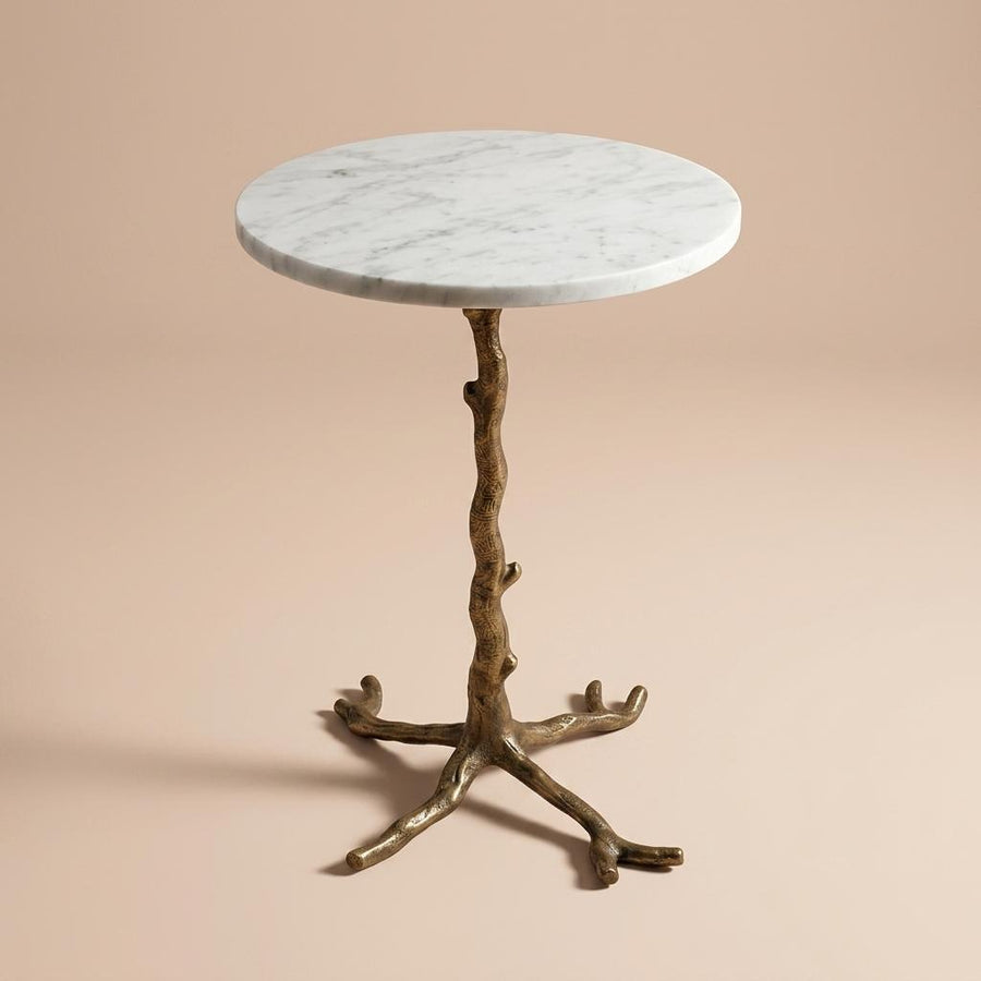 Side table with marble top and branch-like base on a beige background