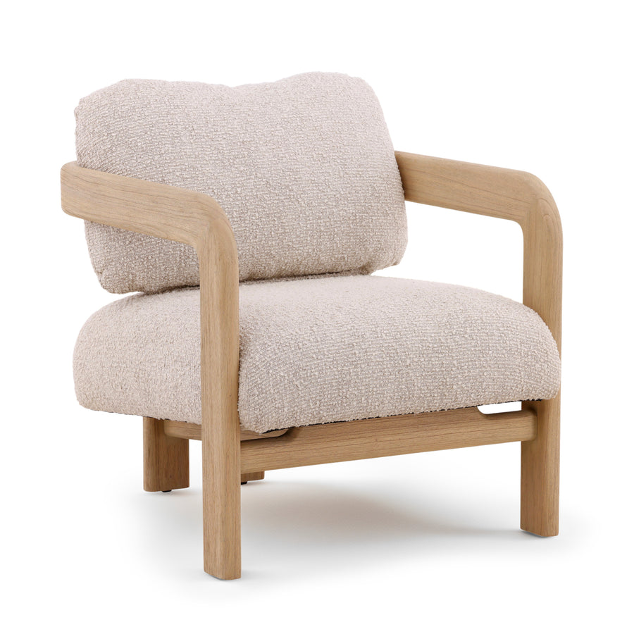 A cream boucle fabric upholstered armchair with a light natural wood frame and a loose back cushion
