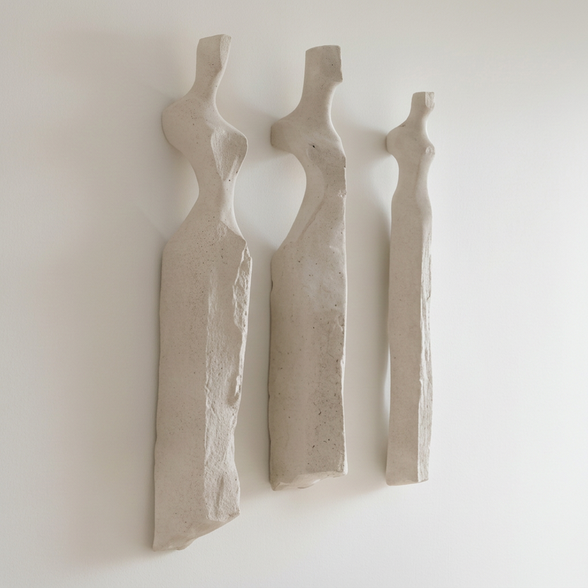 Three abstract stone sculptures on a white background
