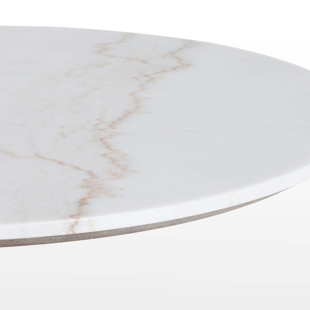 Close-up of a round marble tabletop featuring subtle veining patterns in beige and white, highlighting its elegant texture.