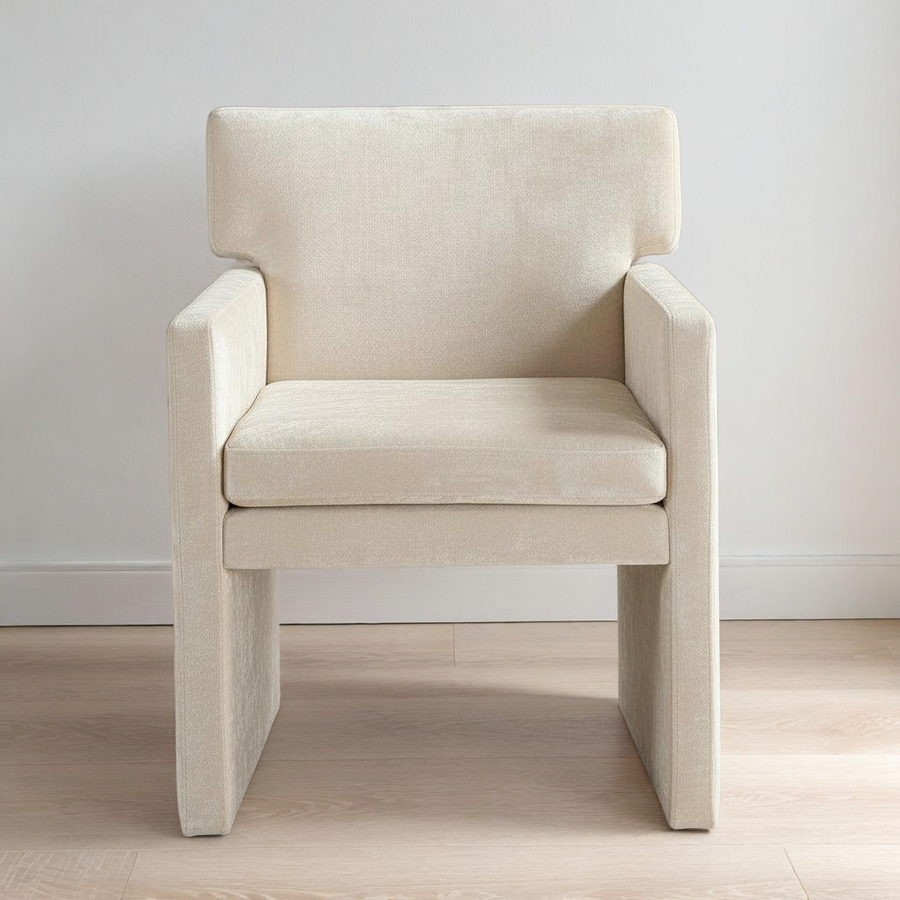 Beige armchair on a wooden floor with a white wall background