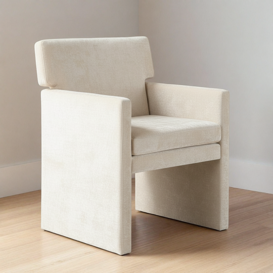 Beige armchair on a wooden floor with a plain wall background