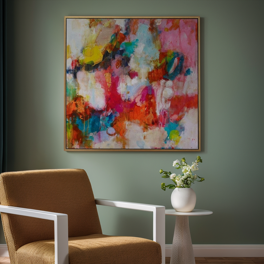 Colorful abstract painting on a wall above a brown chair and small table with a vase of flowers.
