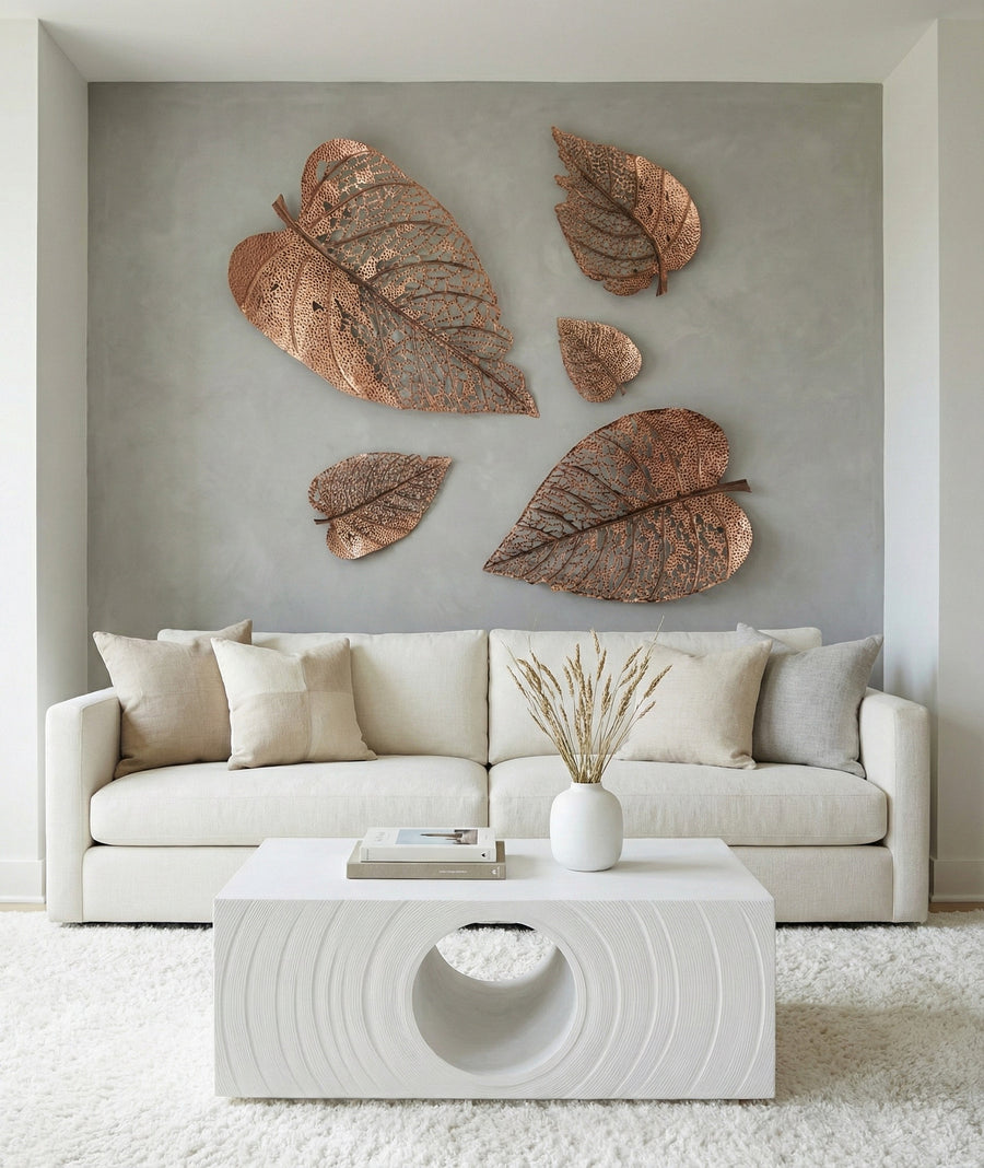 Decorative leaf wall art above a beige sofa in a modern living room.