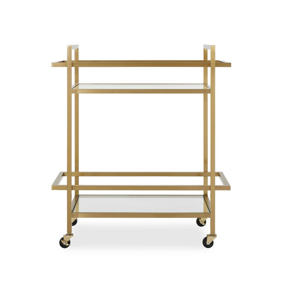 Brass bar cart with glass shelves and wheels, minimalist design against white wall background