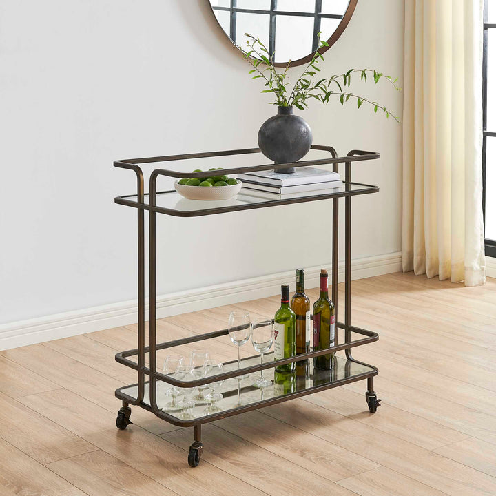 Decorative bar cart with bottles and glasses on a wooden floor.
