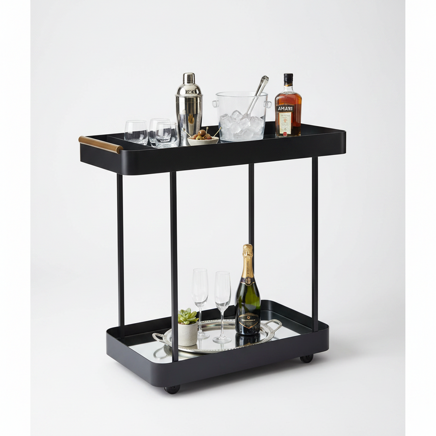 A black two-tier rolling bar cart with a mirrored lower tray, styled with cocktail and bar accessories, a bottle of Aperol, and a bottle of champagne