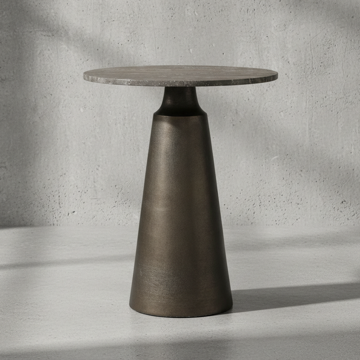 Modern side table with a round top and cone-shaped base on a neutral background