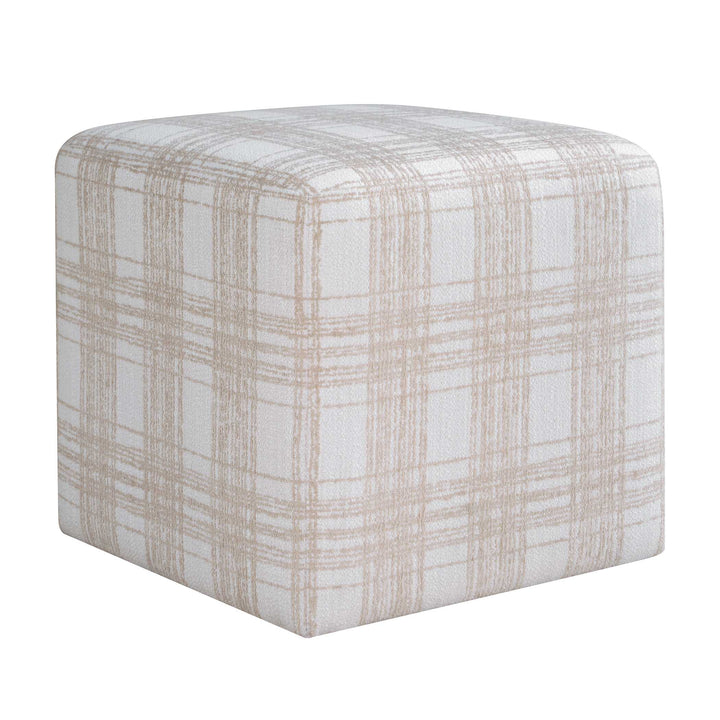 Textured cube-shaped ottoman on a wooden floor with neutral walls.