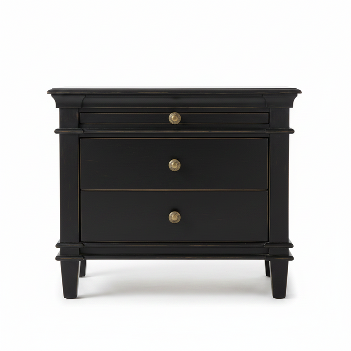 A black wooden nightstand with three drawers and brass knobs