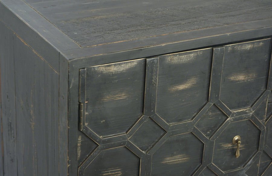 Close-up of a dark wooden cabinet with geometric pattern and gold handle