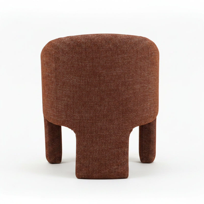 modern armchair with curved backrest and armrests, upholstered in rust-brown textured fabric, boxy yet rounded silhouette