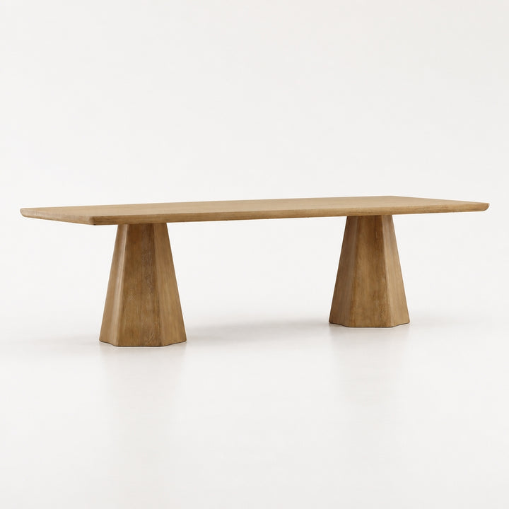 A minimalist wooden table with a rectangular top and two tapered triangular pedestal bases, shown on a seamless white studio background.