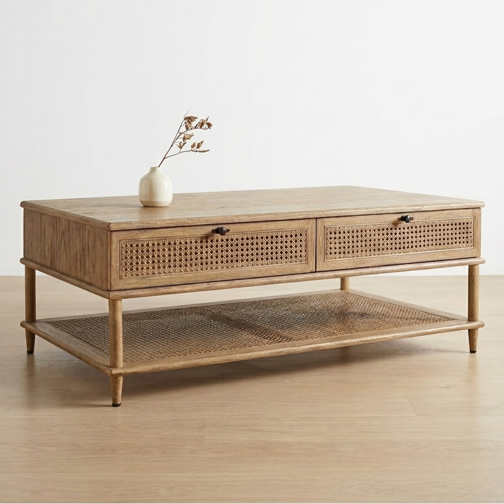 Wooden coffee table with wicker drawers and shelf on a light wooden floor.