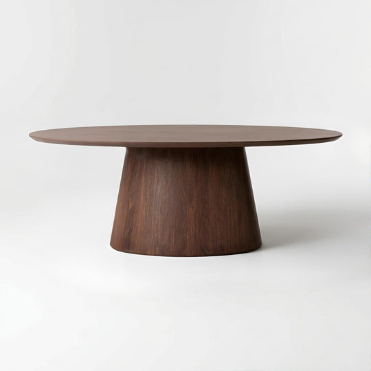 A modern oval dining table with a dark brown wood grain top and a tapered conical pedestal base, photographed on a seamless light gray studio background.