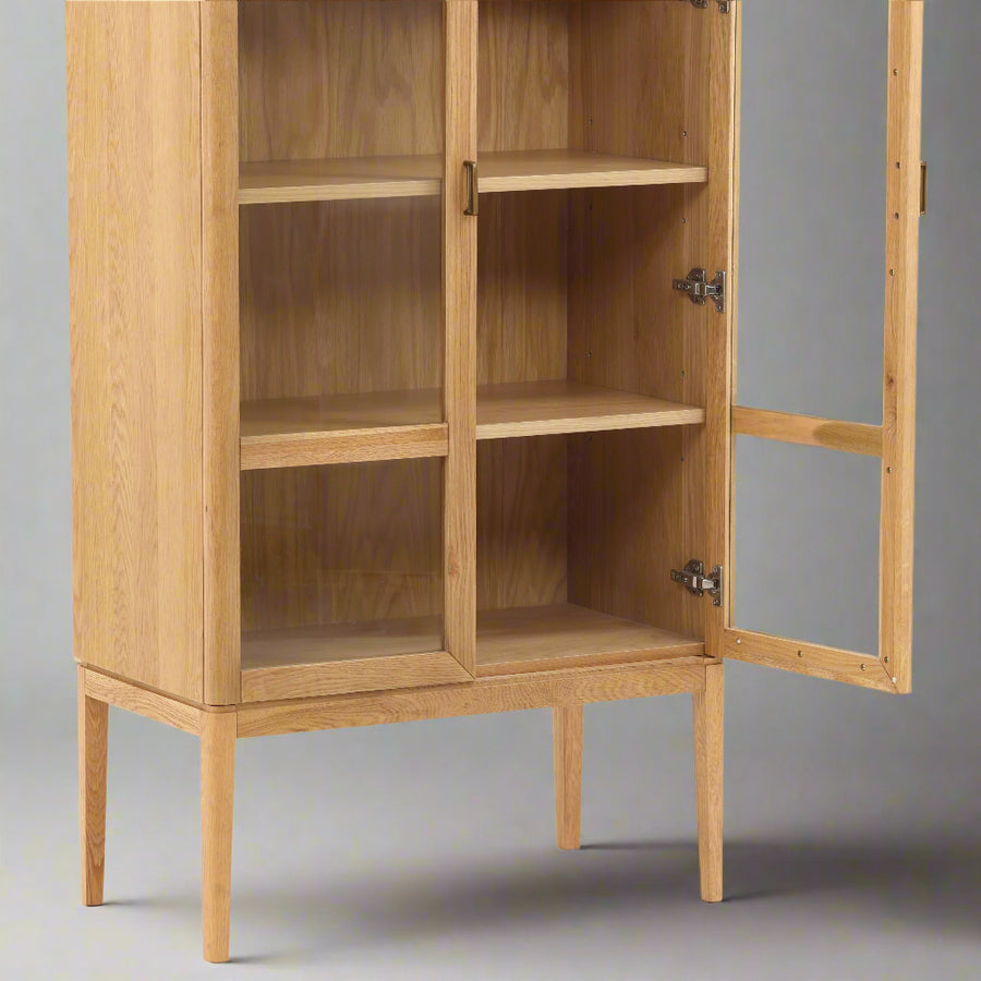 A wooden display cabinet with glass doors, showcasing three shelves and elegant legs, partially open to reveal the interior.