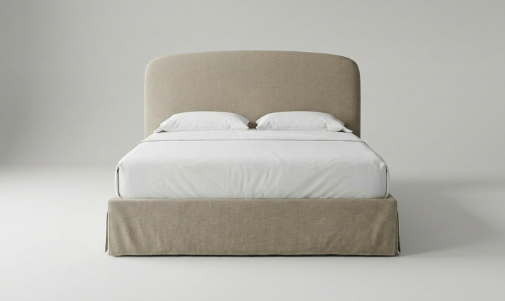 Beige upholstered bed with white bedding on a plain background